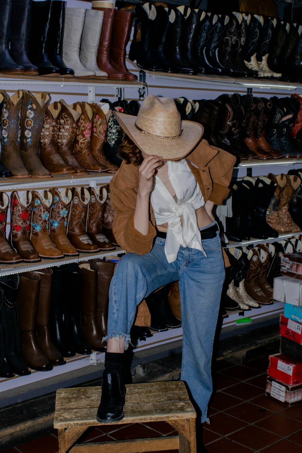 a woman sitting on a stool in a shoe store