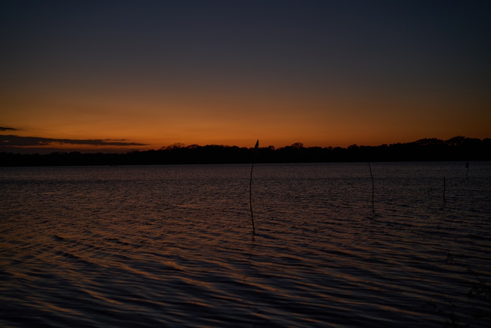 a body of water with a sunset in the background