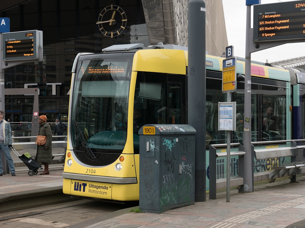 Um ônibus amarelo estacionado em um ponto de ônibus