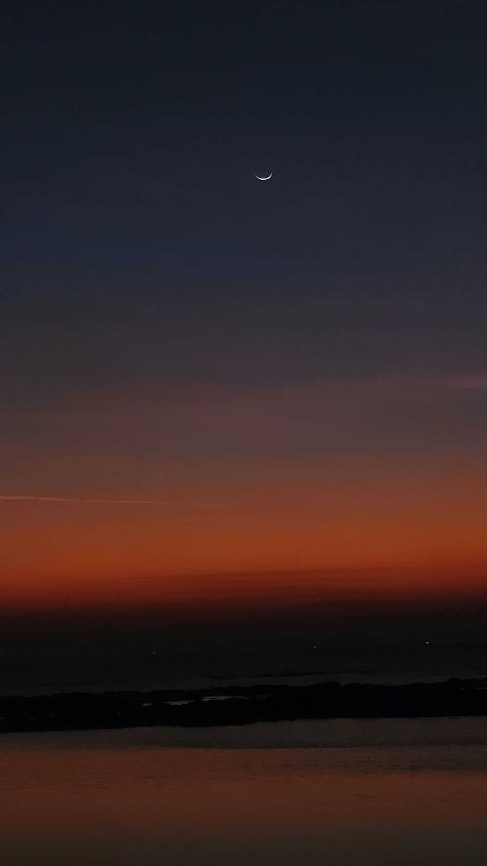 空に月が浮かぶ夕焼けの眺め