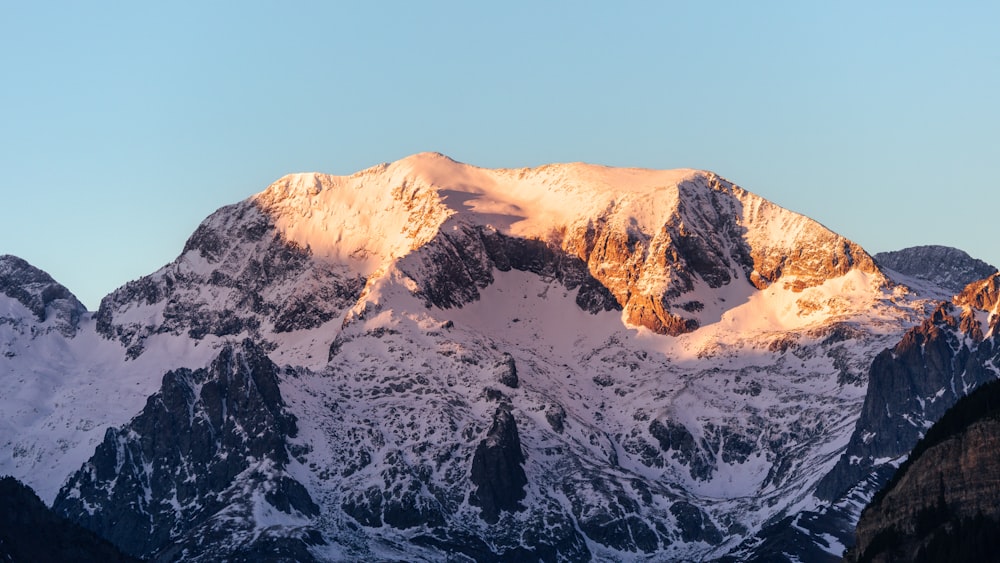 a snow covered mountain with a blue sky in the background