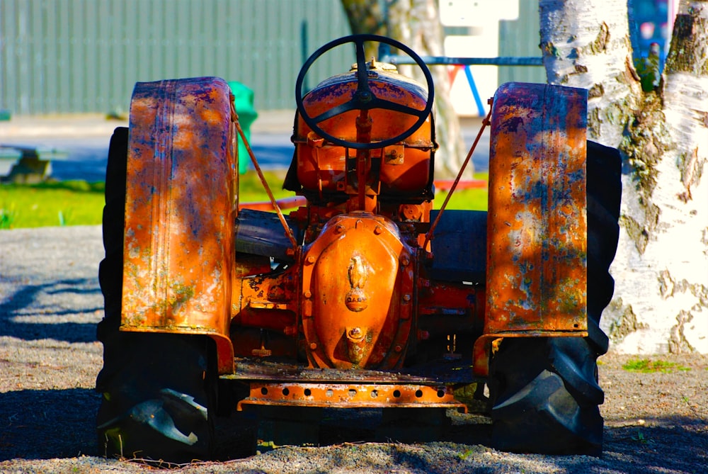a rusted out tractor sitting on the side of a road