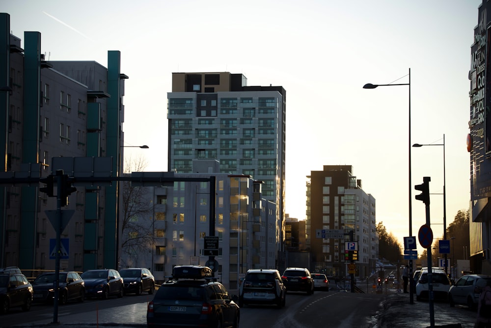 a city street filled with lots of traffic next to tall buildings