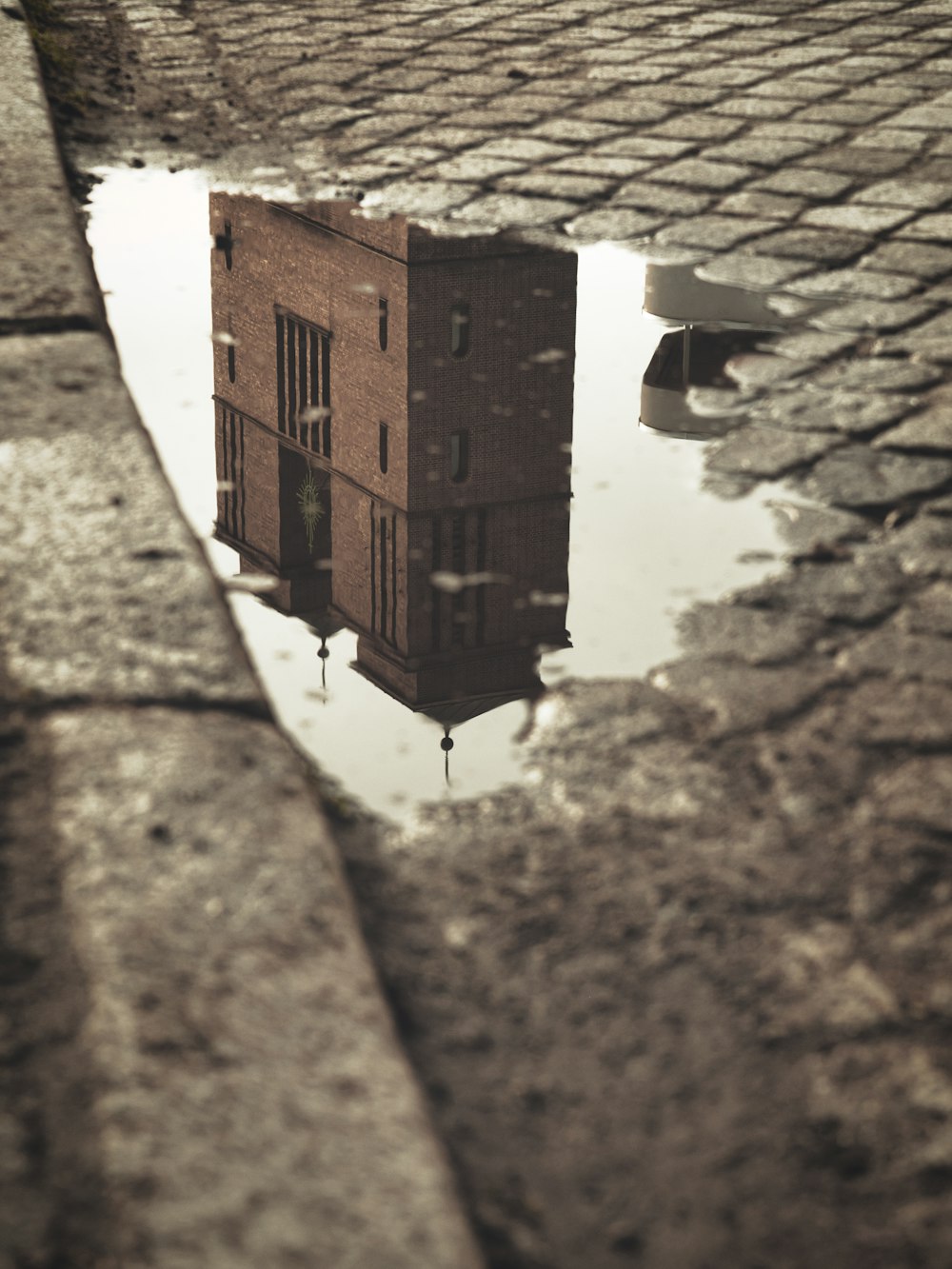 a reflection of a building in a puddle of water