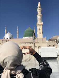 a woman making a heart shape with her hands
