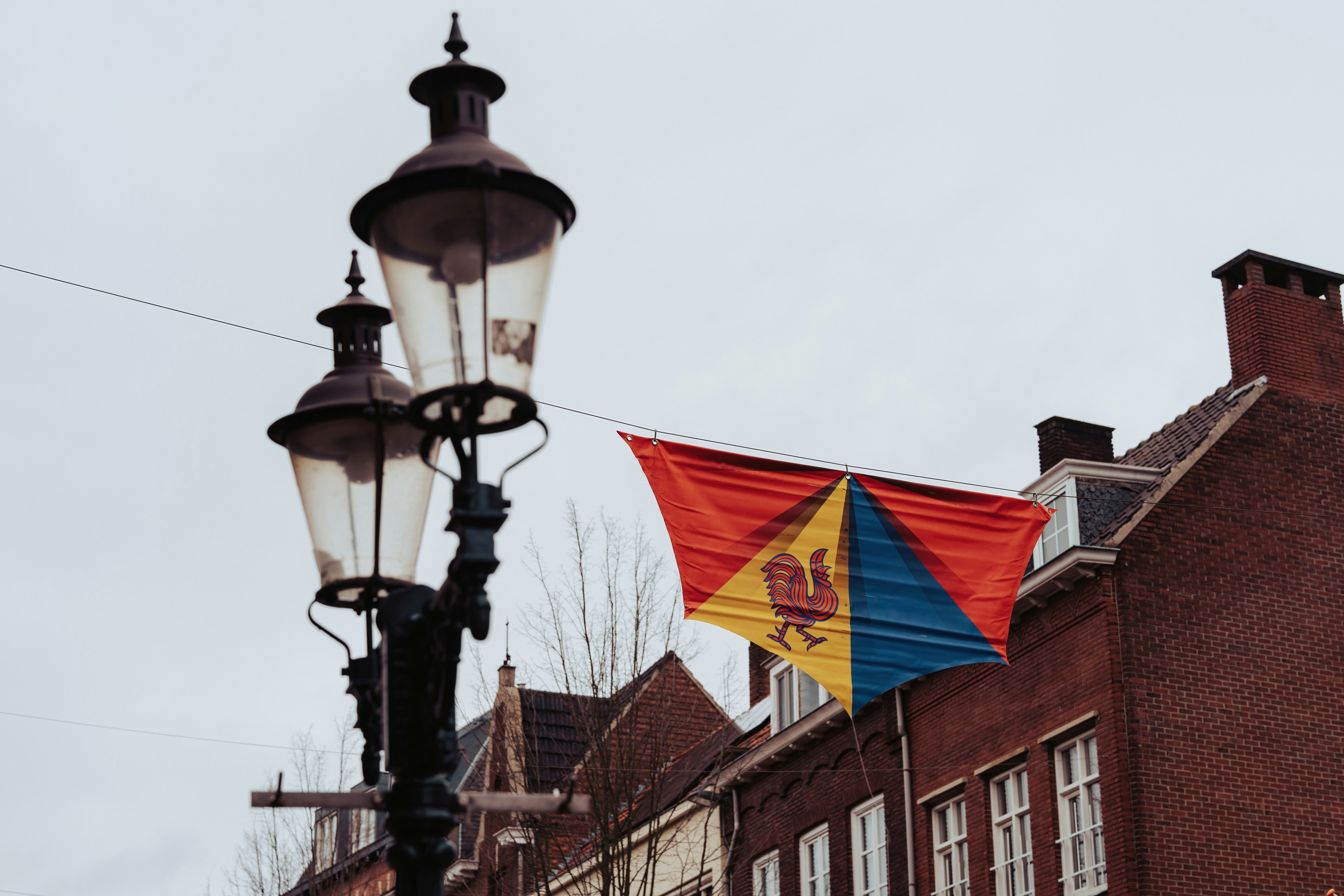 a street light with a flag hanging off of it's side