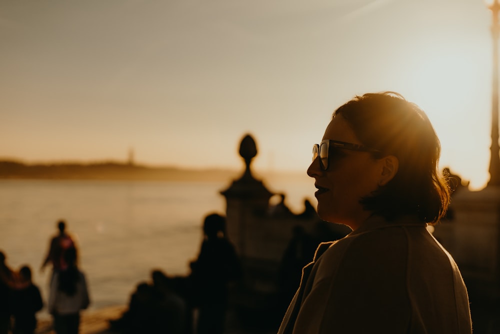 a woman standing in front of a body of water