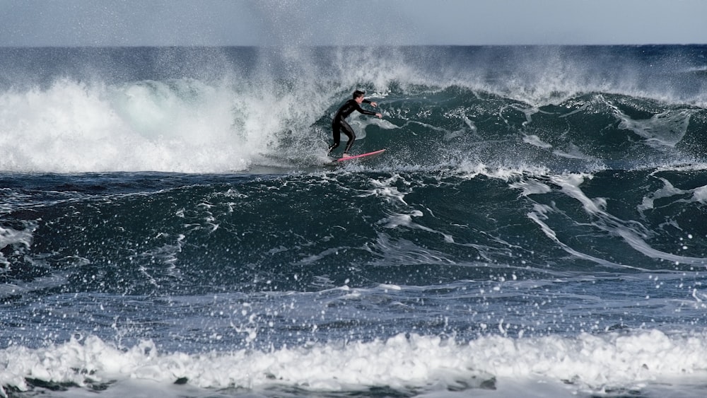 a man riding a wave on top of a surfboard