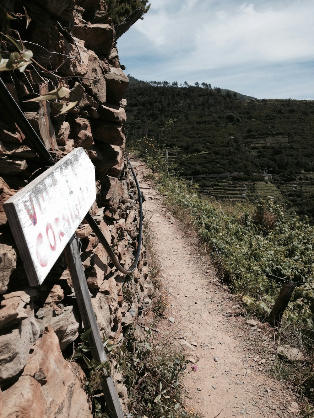 a sign that is on the side of a rock wall