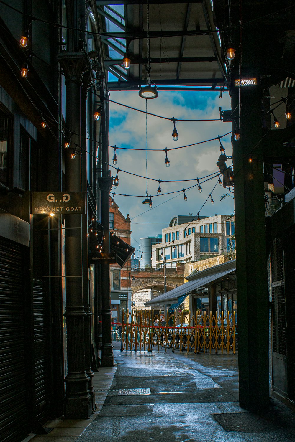 a city street with a bunch of lights hanging from the ceiling