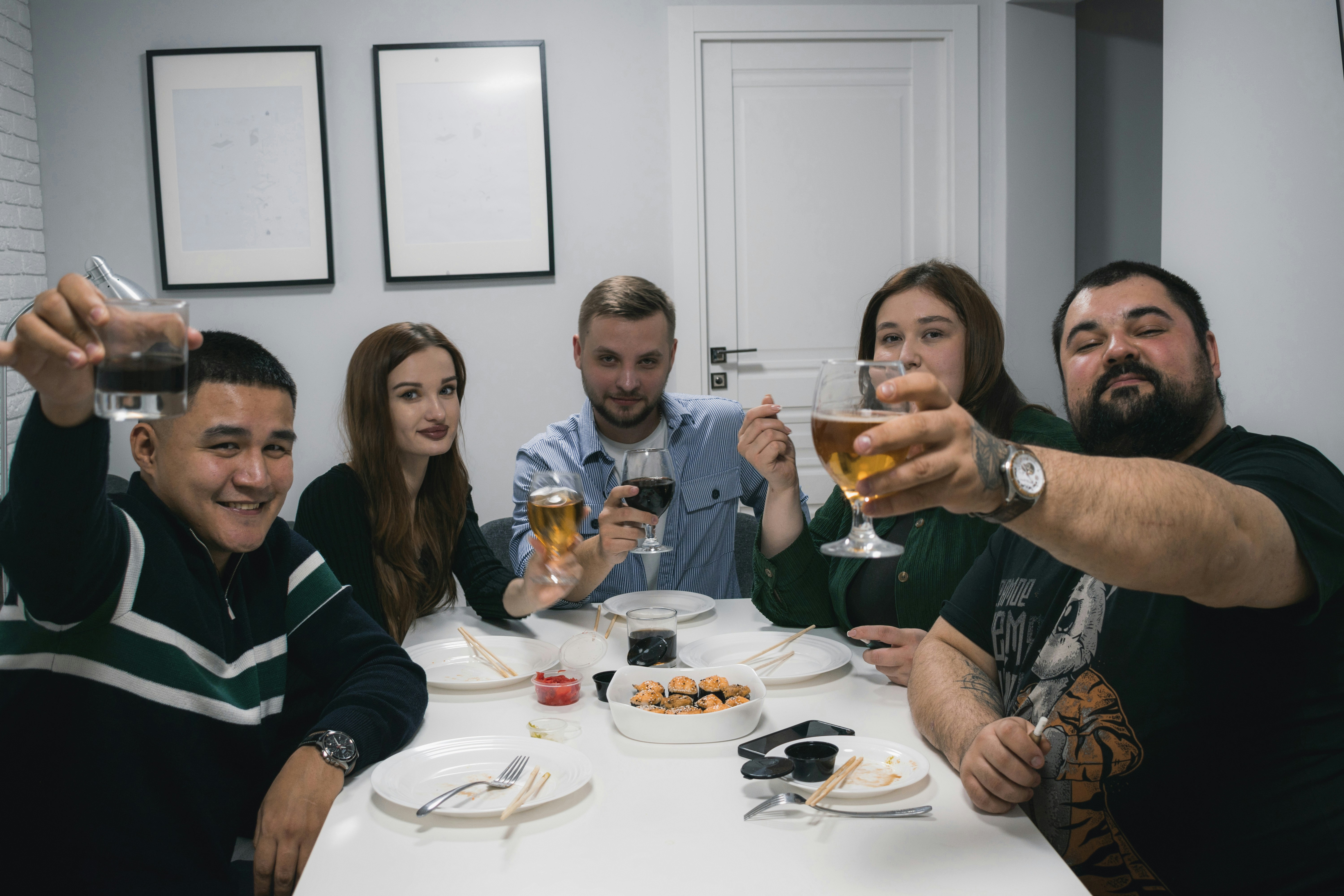 테이블에 둘러앉아 와인을 마시고 있는 한 무리의 사람들