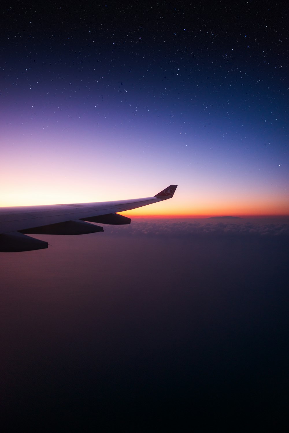 the wing of an airplane as the sun sets