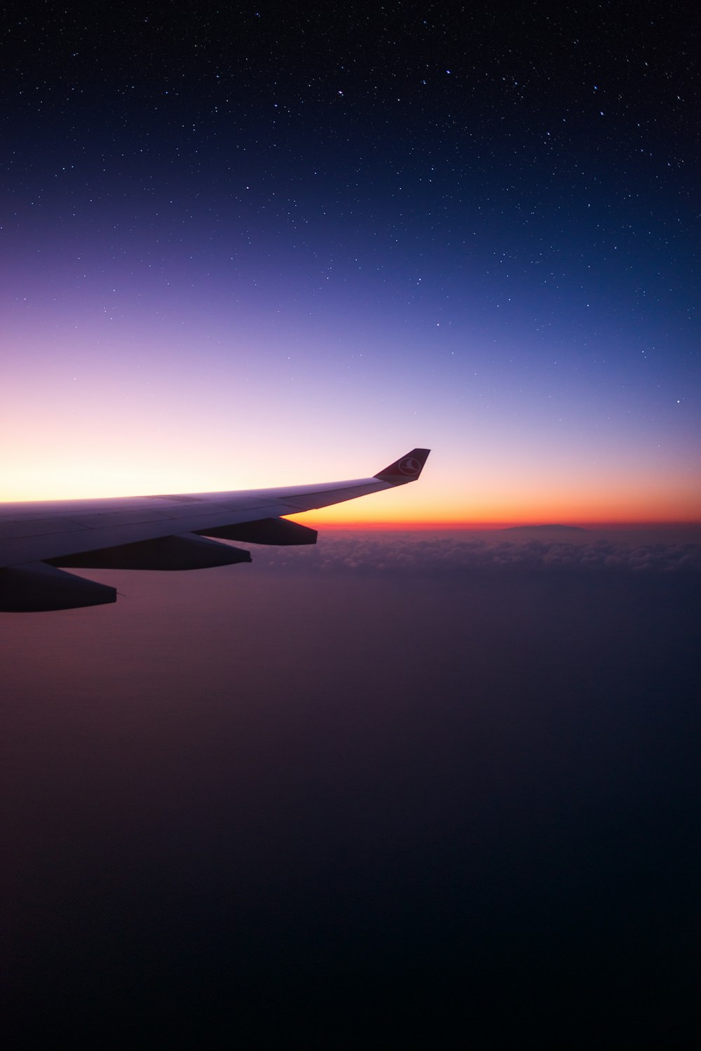 der Flügel eines Flugzeugs bei Sonnenuntergang