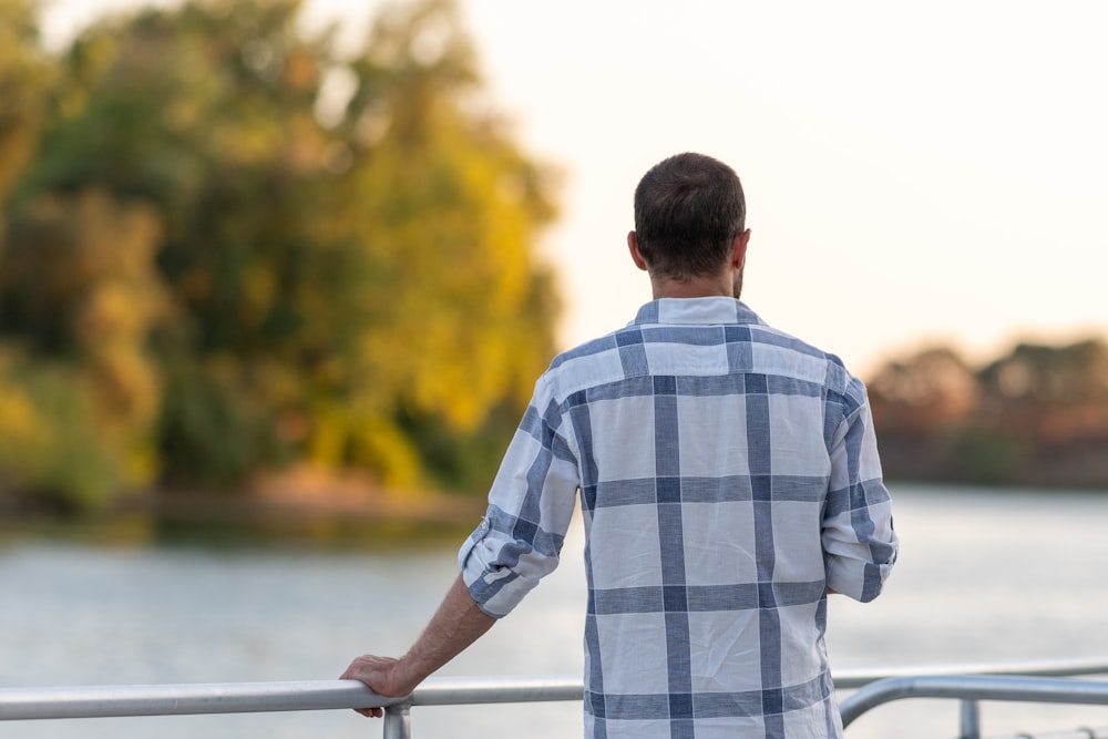 a man standing on a boat looking at the water