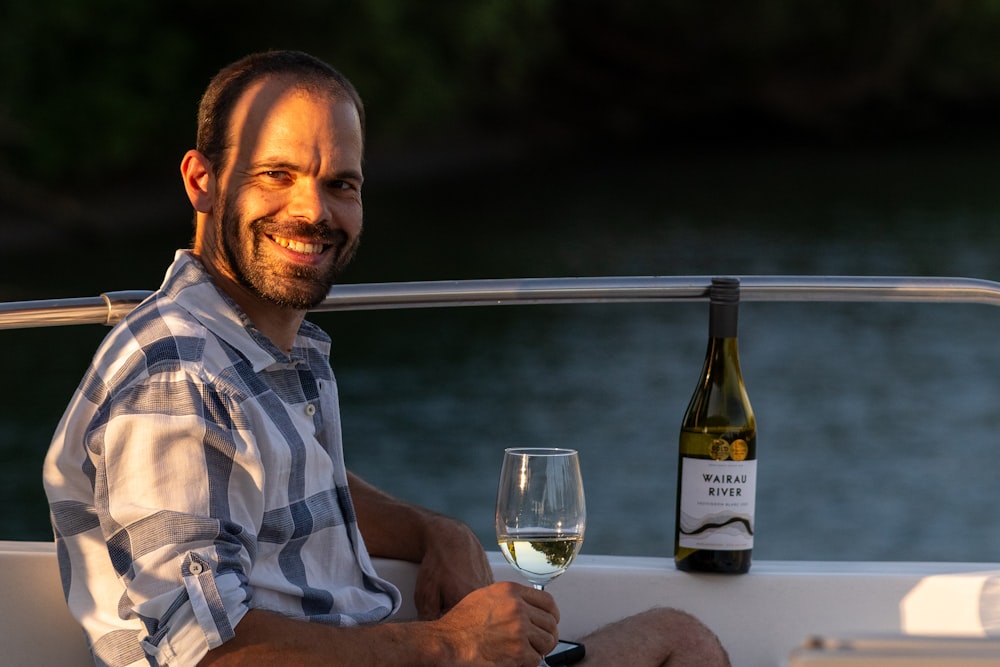 a man sitting on a boat with a glass of wine