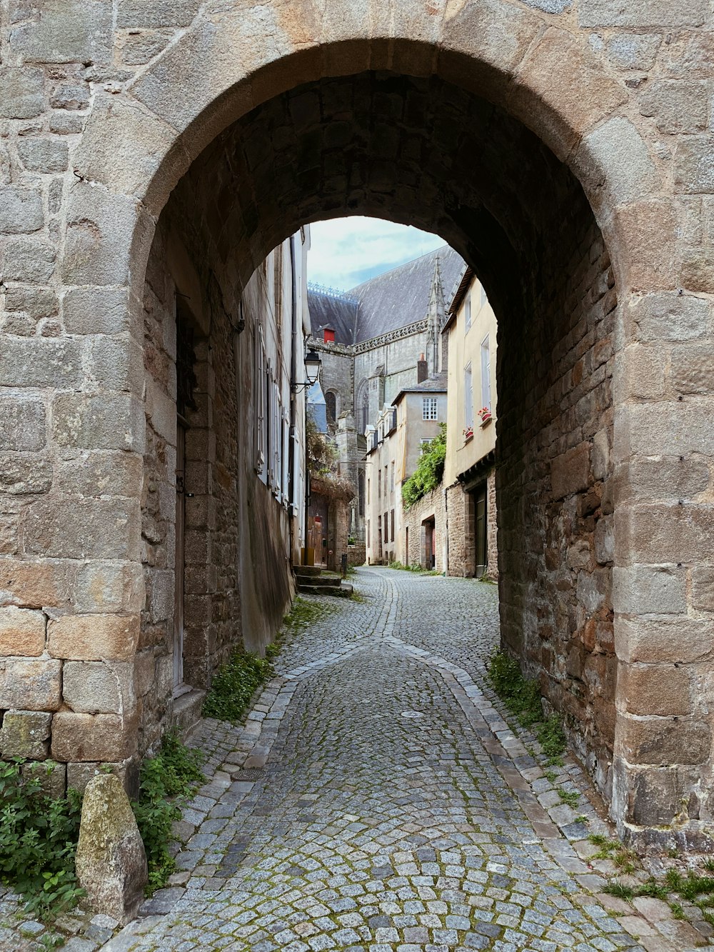 a cobblestone street with a stone archway