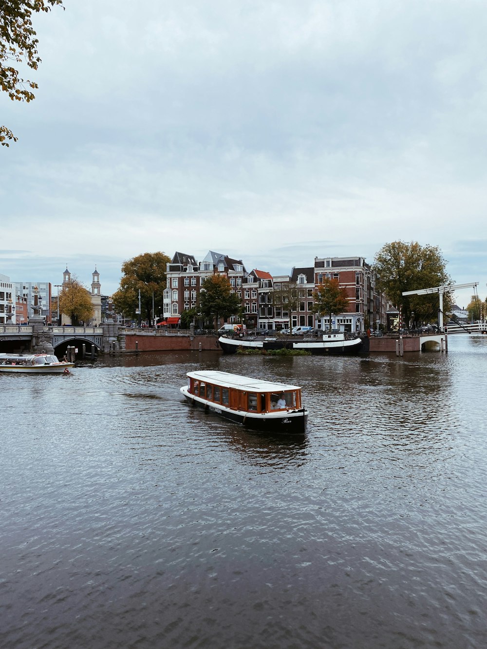 a boat traveling down a river next to a city