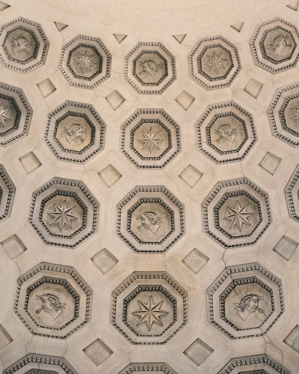 a close up of a ceiling with a bunch of carvings on it