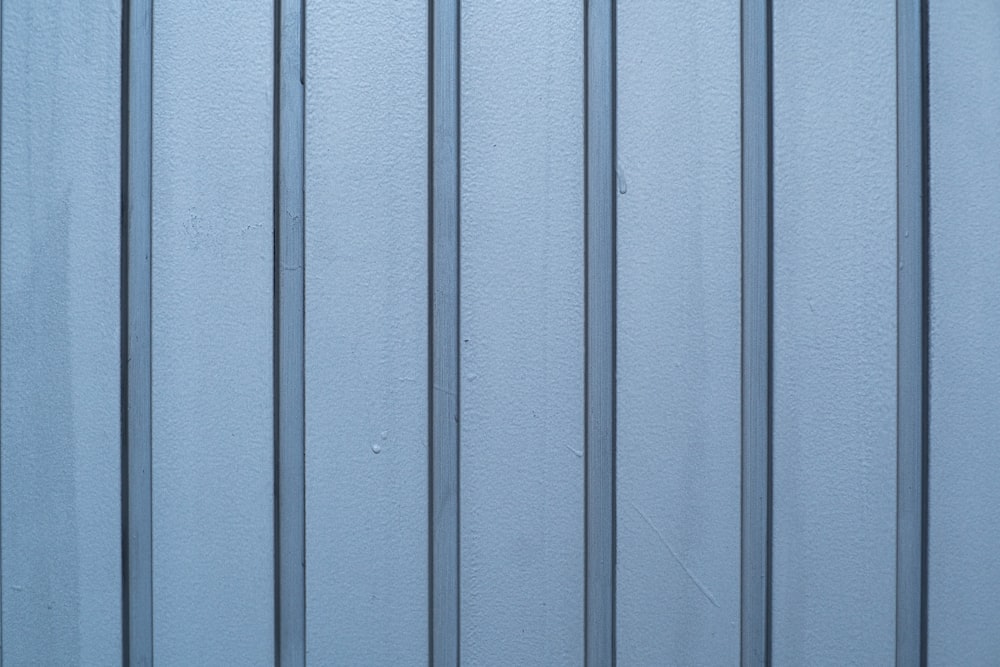 a close up of a blue metal wall