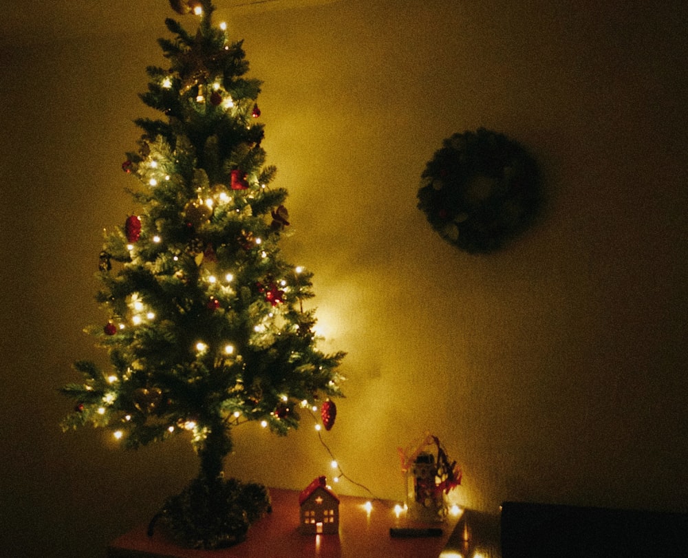 a lit christmas tree in a corner of a room