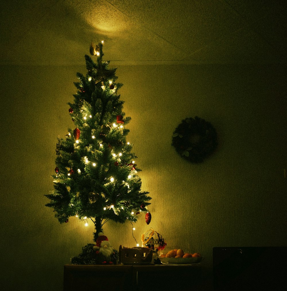 a lit christmas tree in the corner of a room