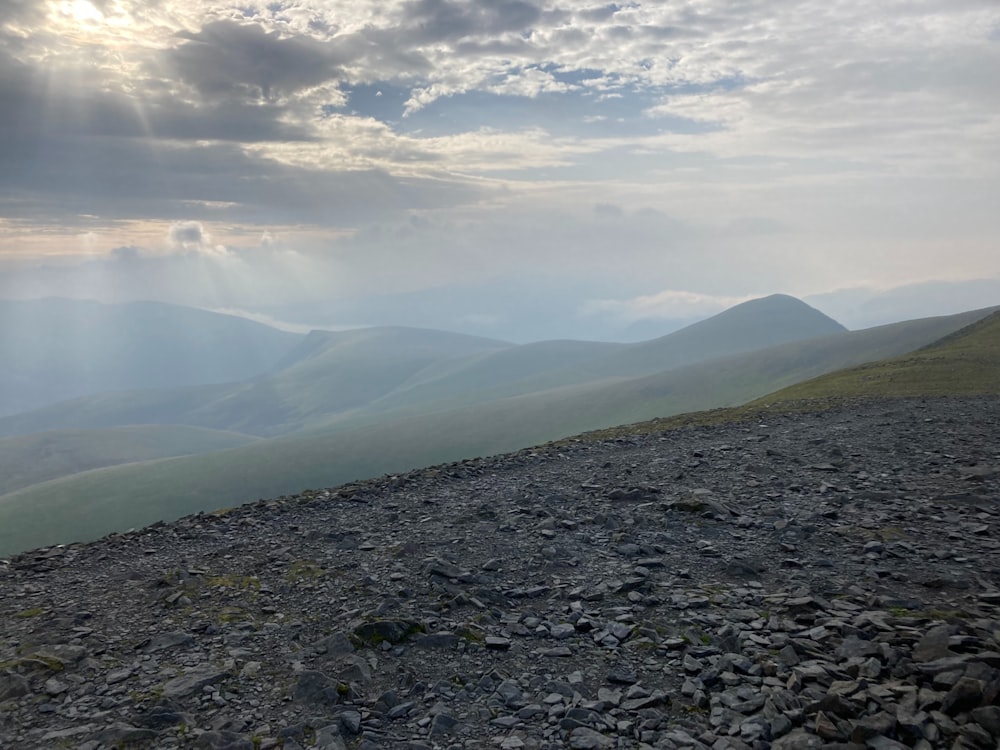 the sun shines through the clouds over the mountains