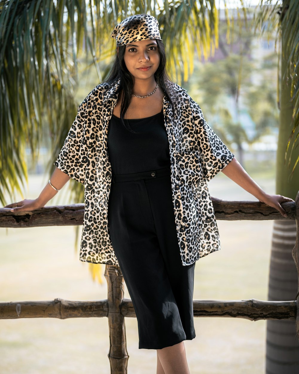 a woman in a black dress and a leopard print jacket