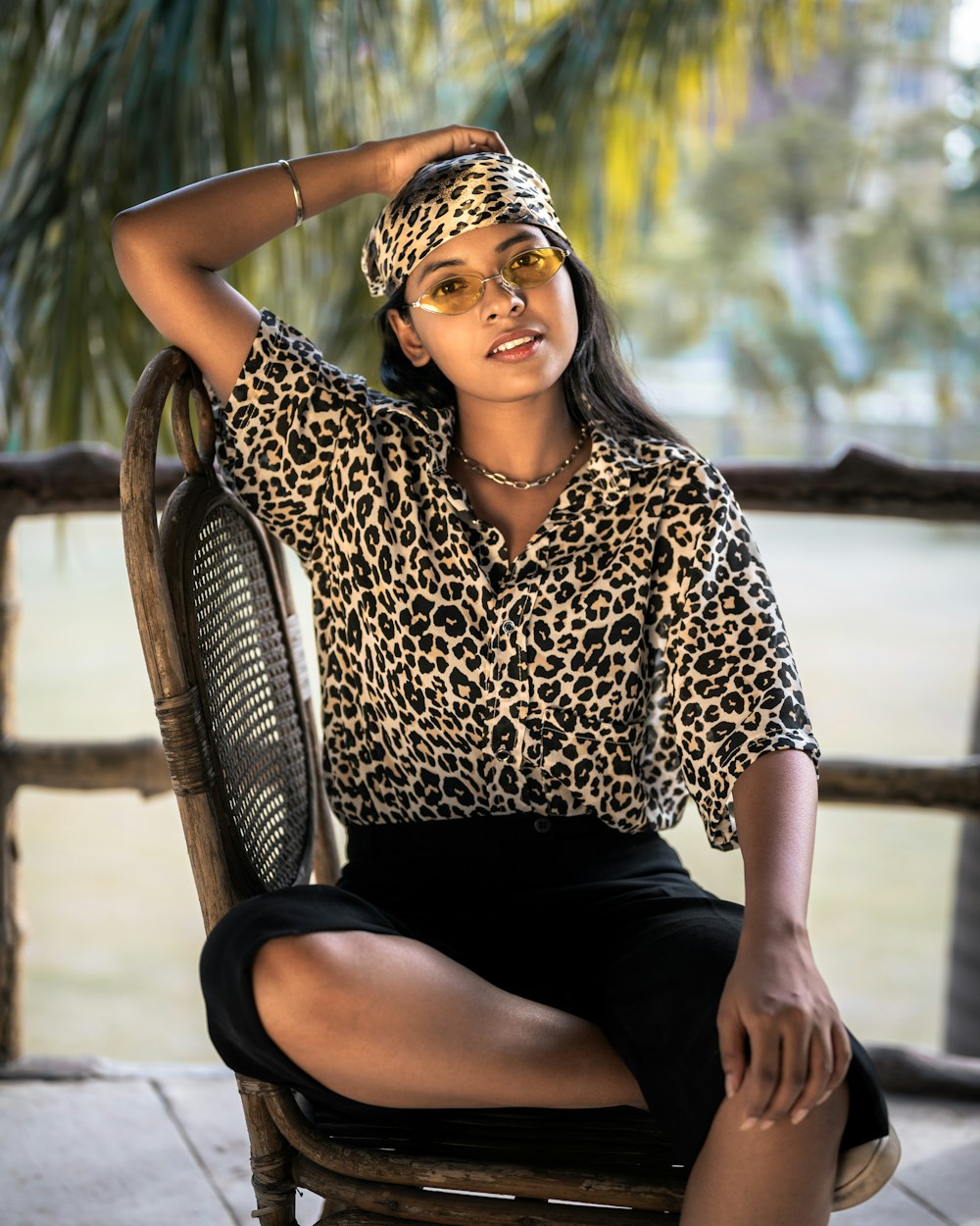 a woman sitting in a chair wearing a leopard print shirt
