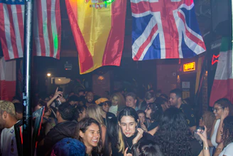 a crowd of people standing around a bar