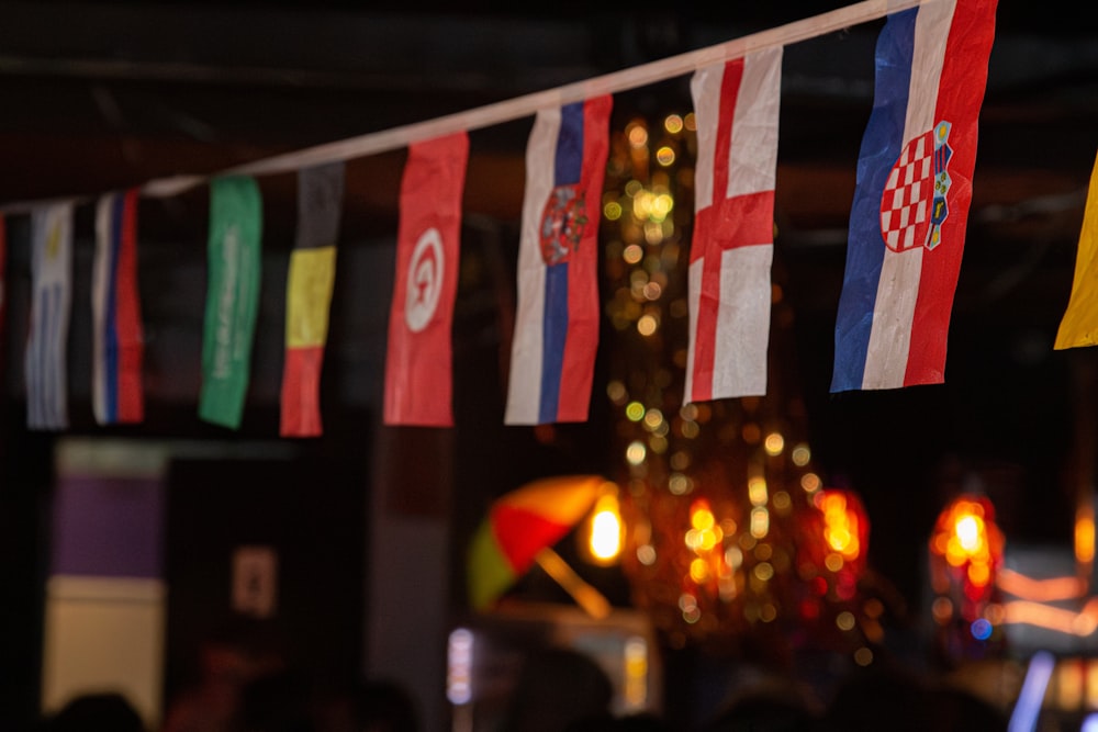 a group of flags hanging from a ceiling