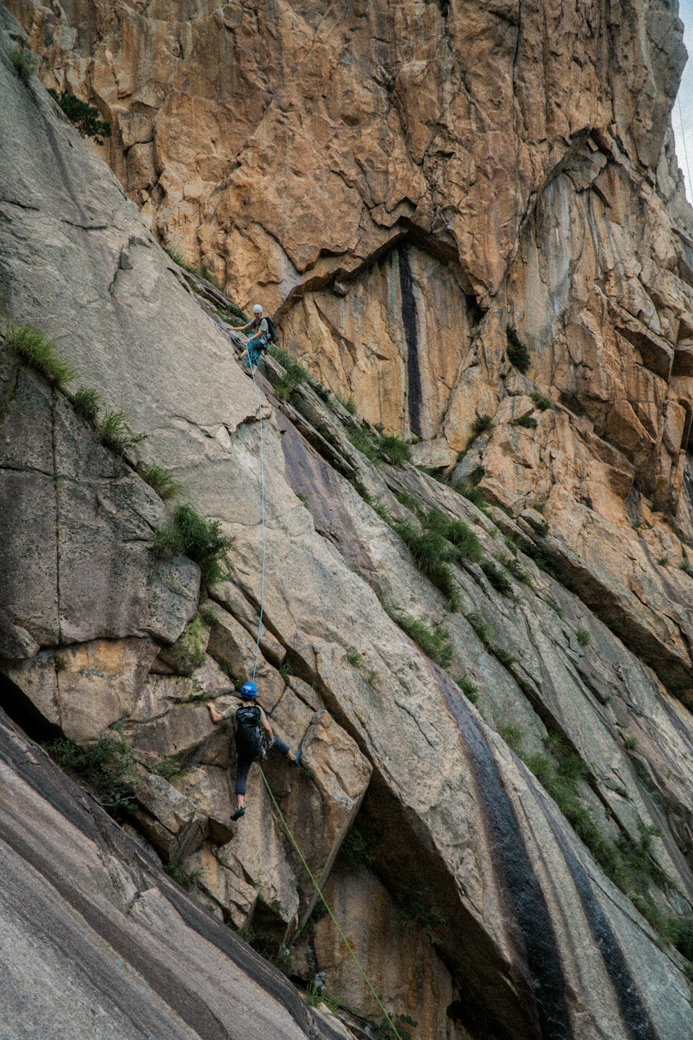 a person climbing up a steep rock face