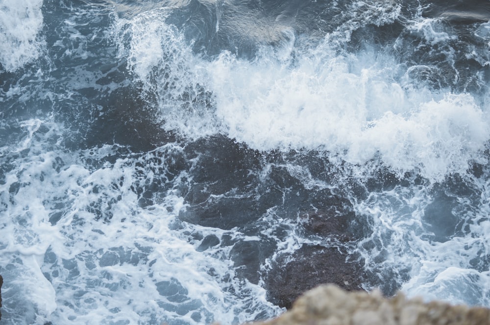 una persona in piedi su una roccia vicino a uno specchio d'acqua