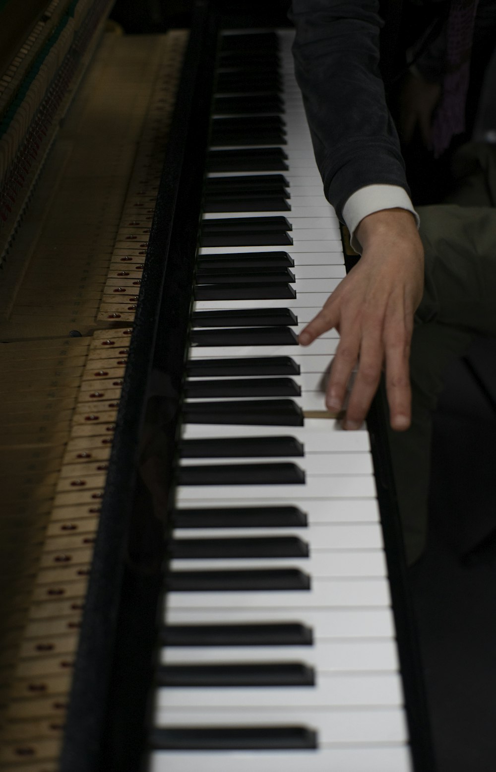 a person sitting at a piano with their hand on the keys