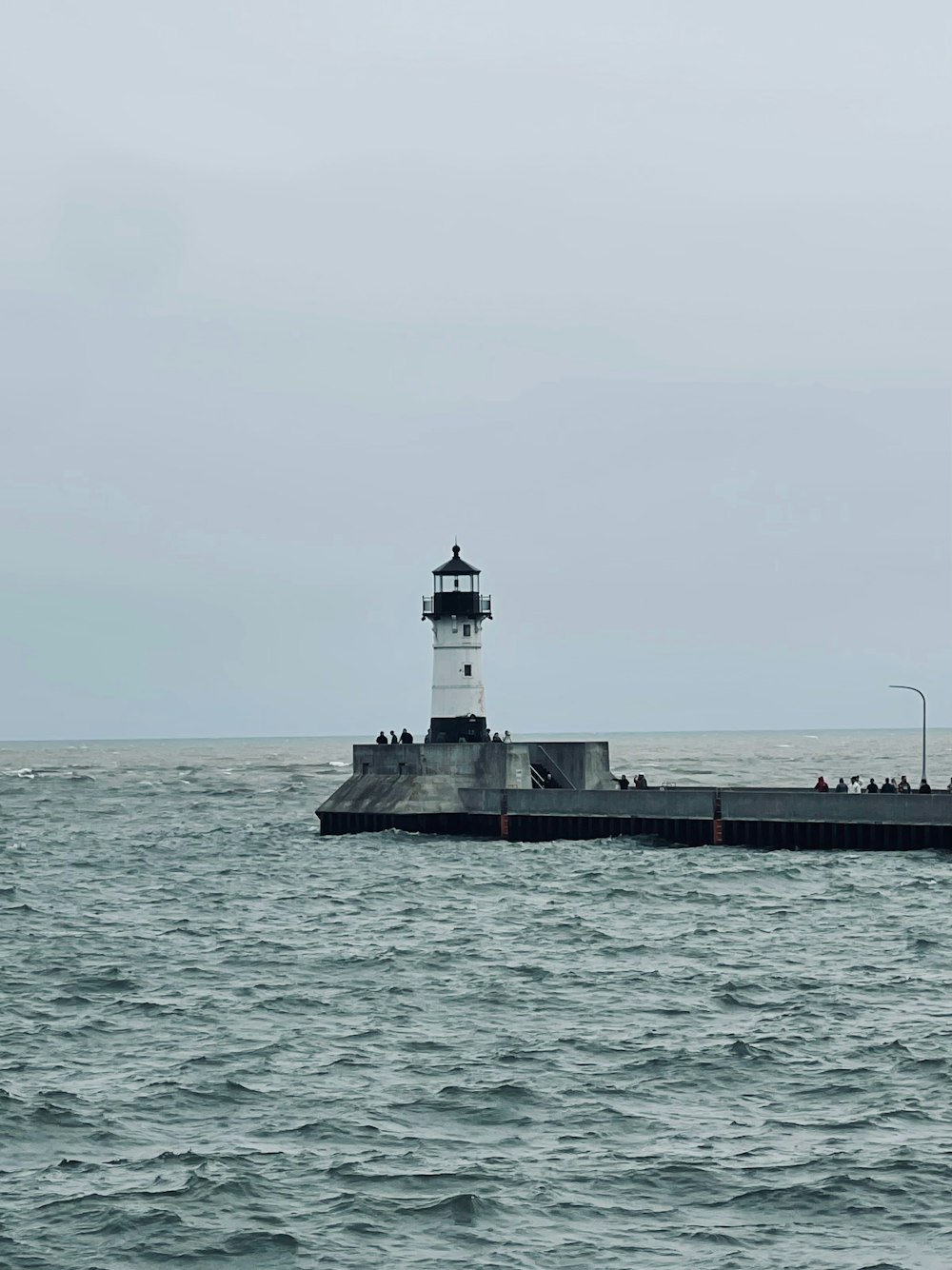 a light house sitting on top of a pier next to the ocean