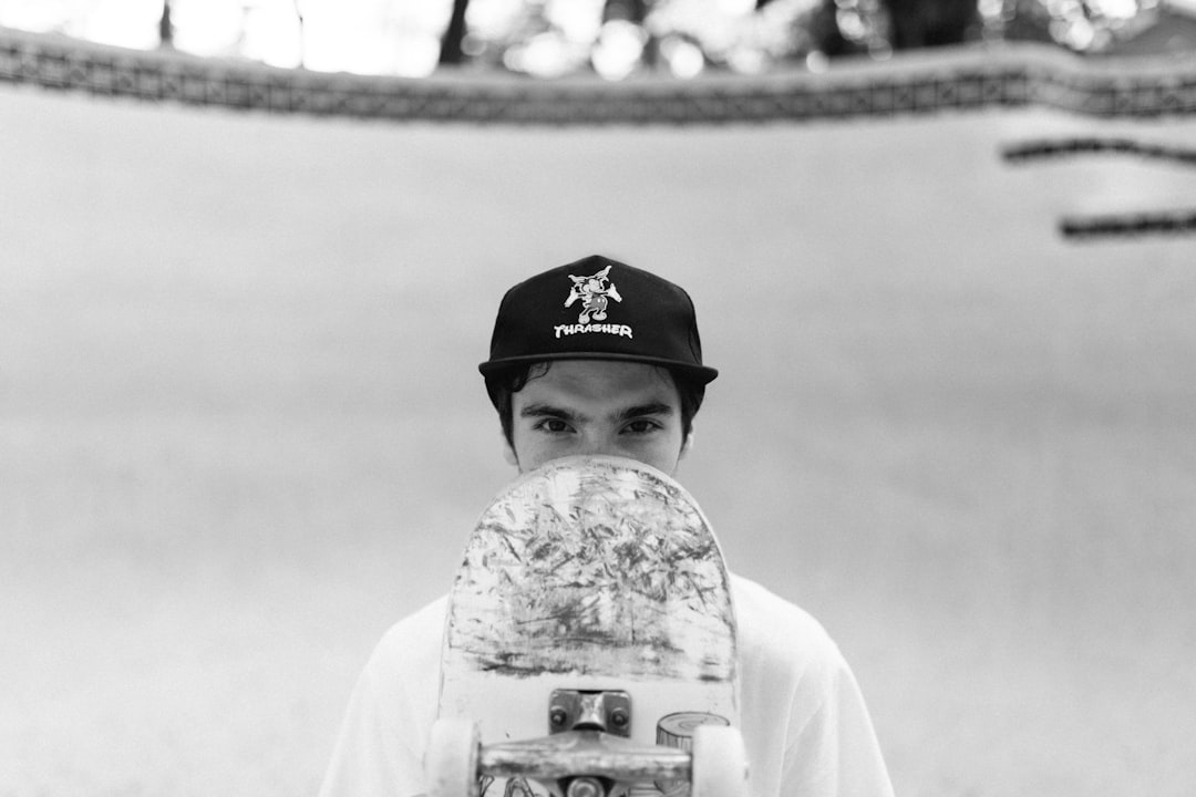 a man holding a skateboard in front of his face