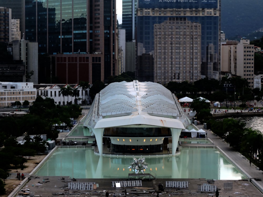 an aerial view of a large building with a pool in front of it