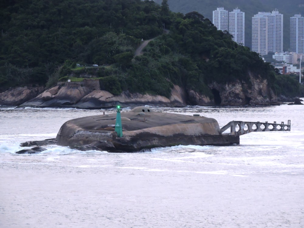 a large rock sitting in the middle of a body of water