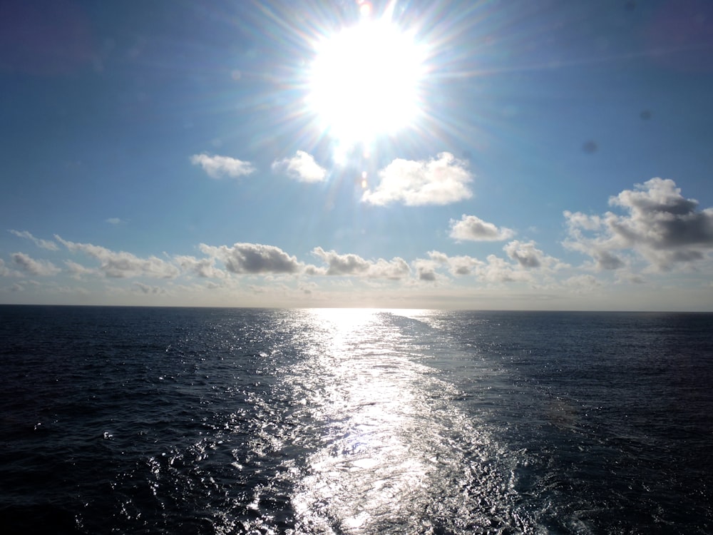 the sun is shining over the ocean on a sunny day