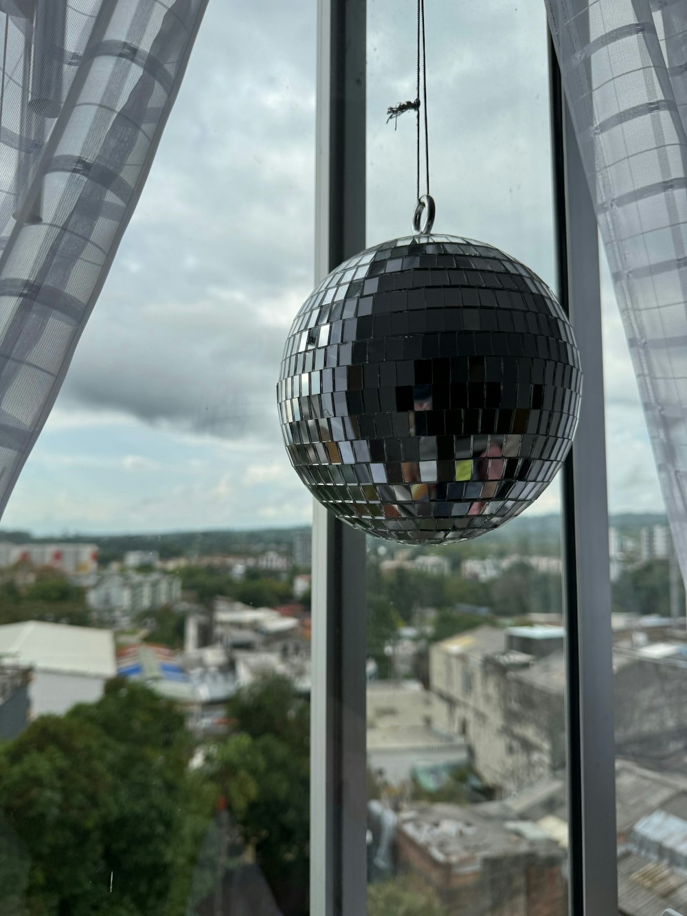 a disco ball hanging from the side of a window