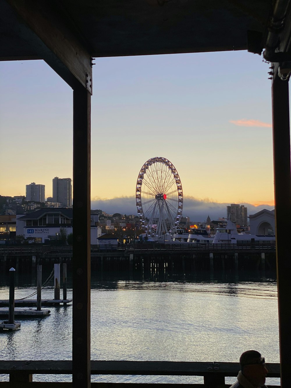 una noria a lo lejos con una ciudad al fondo