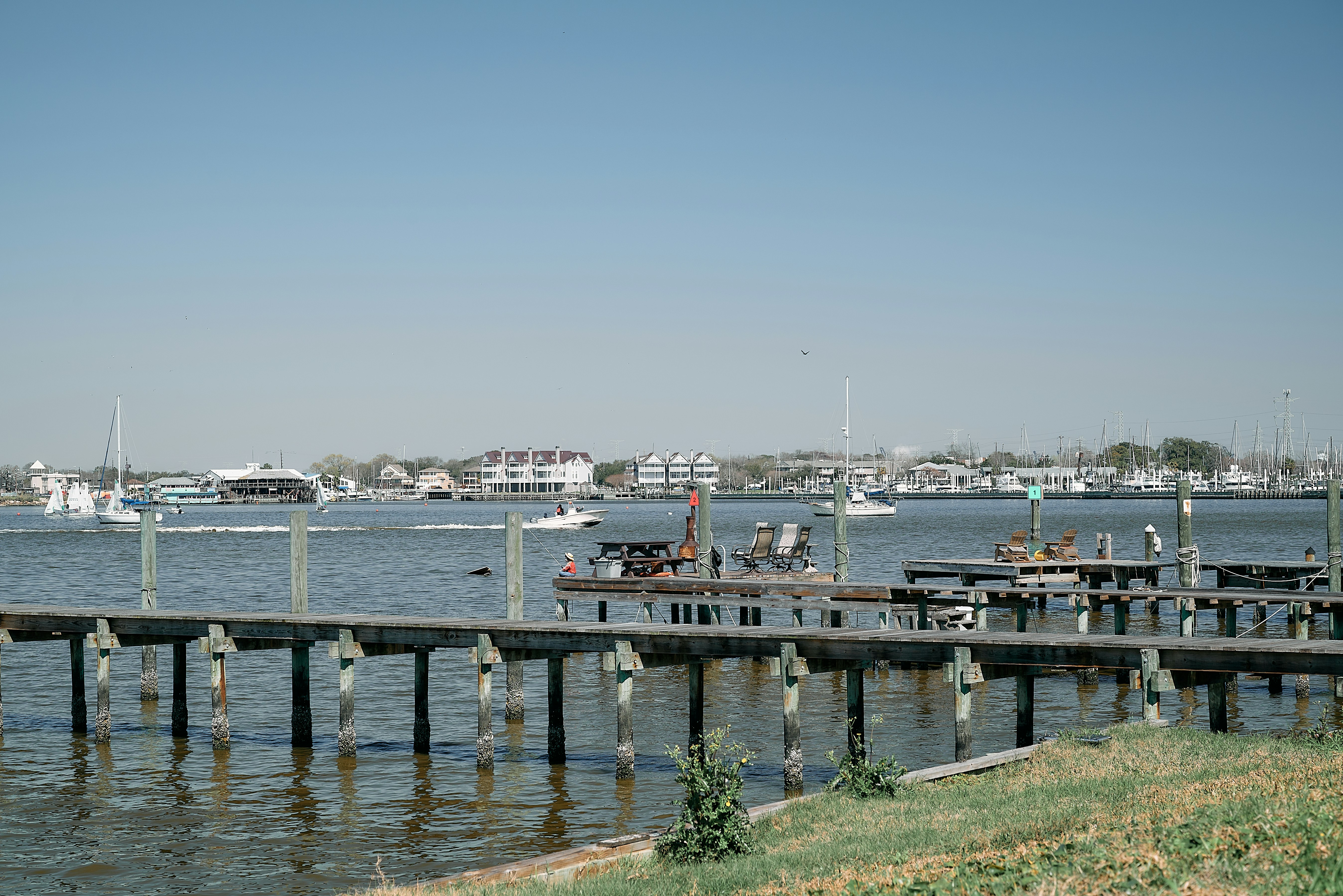 a dock with boats in the water and a sky background