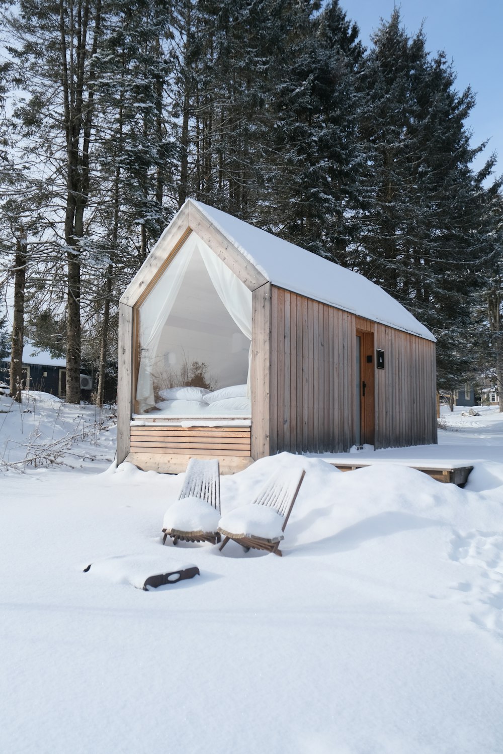 a small cabin in the middle of a snowy forest