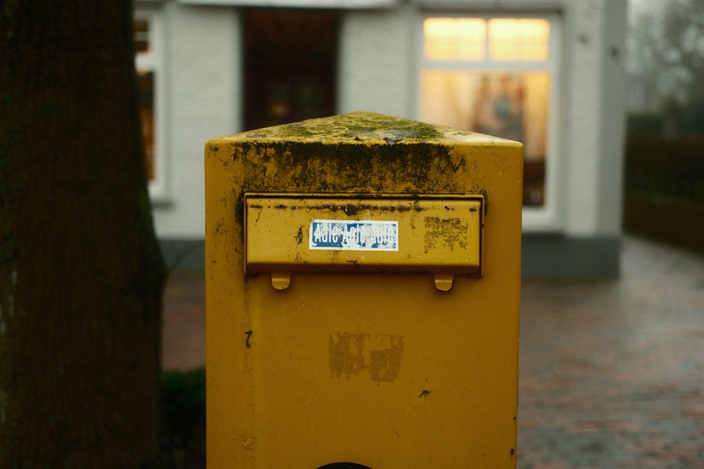 a yellow mailbox sitting on the side of a road