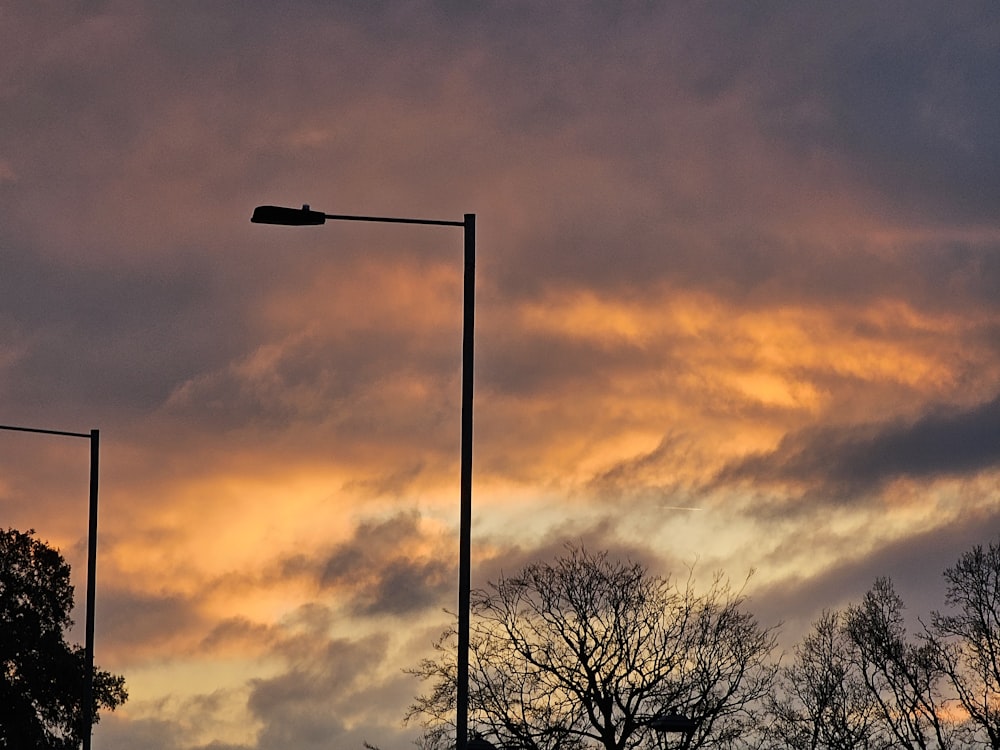 a street light on a pole in front of a cloudy sky