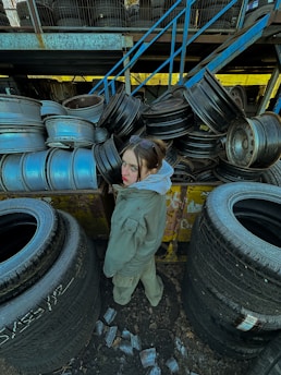 a woman standing next to a pile of tires