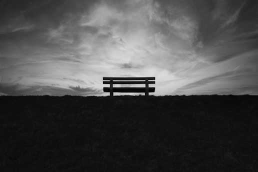 a bench sitting on top of a grass covered field