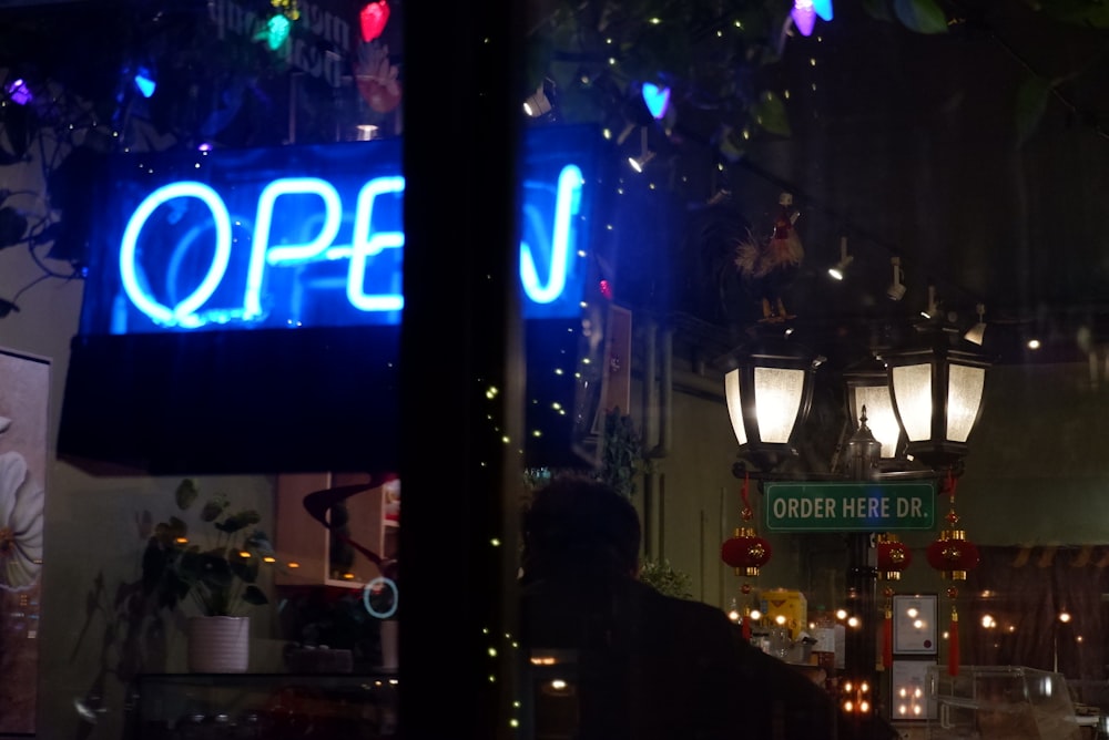 a neon open sign hanging from the side of a building