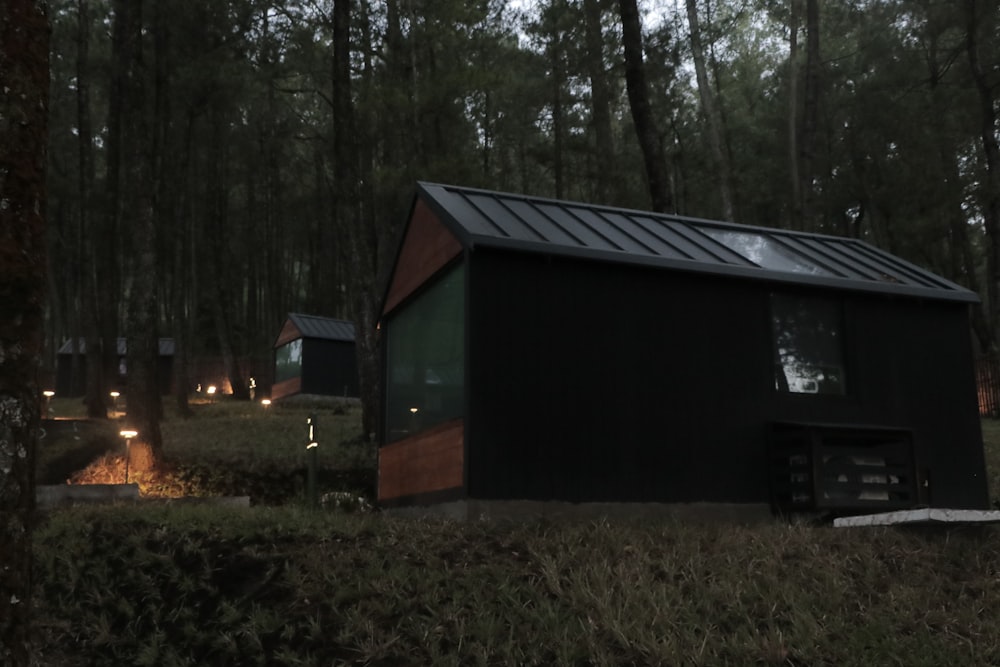 eine kleine Hütte im Wald mit eingeschalteten Lichtern