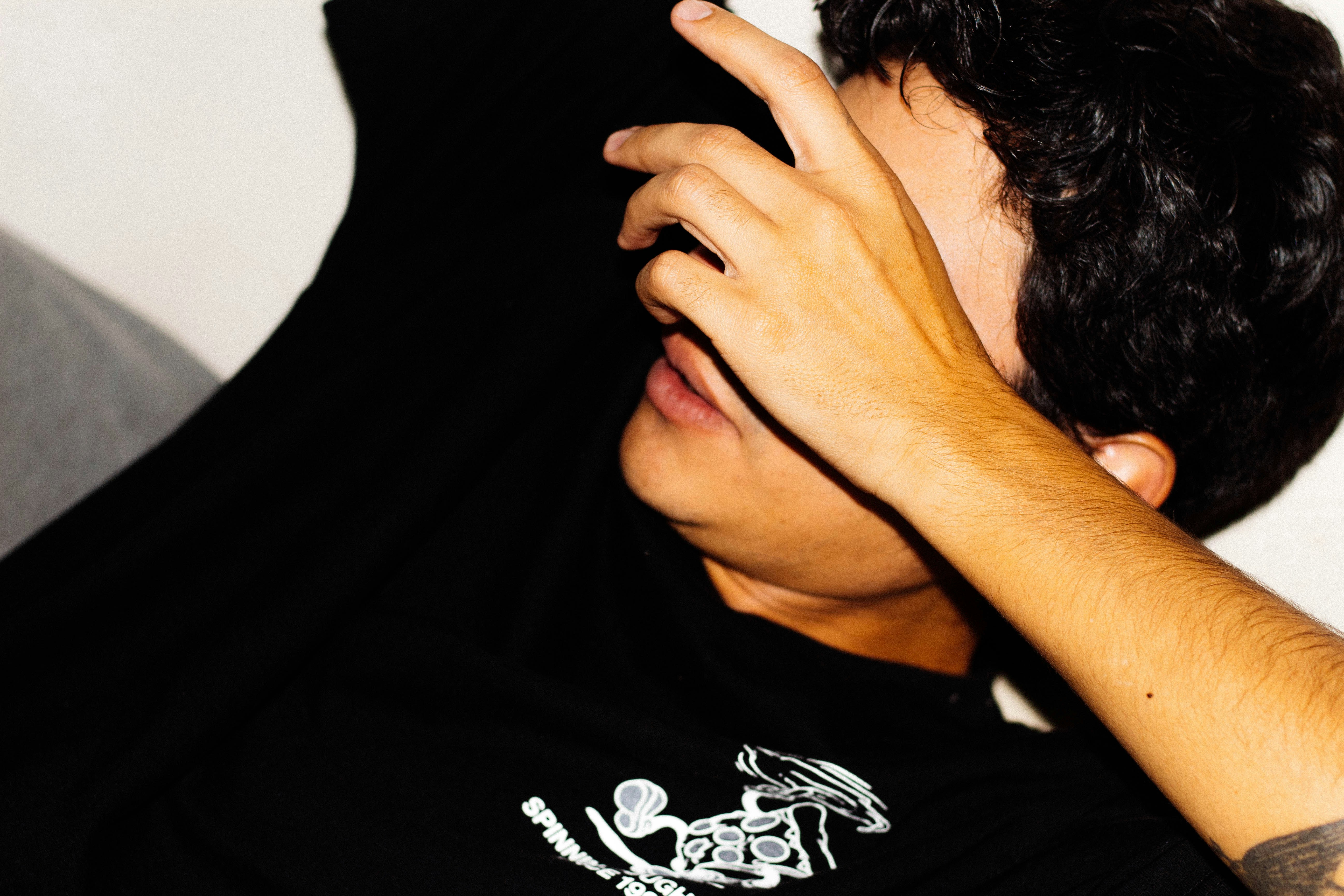 a man covering his face with his hands