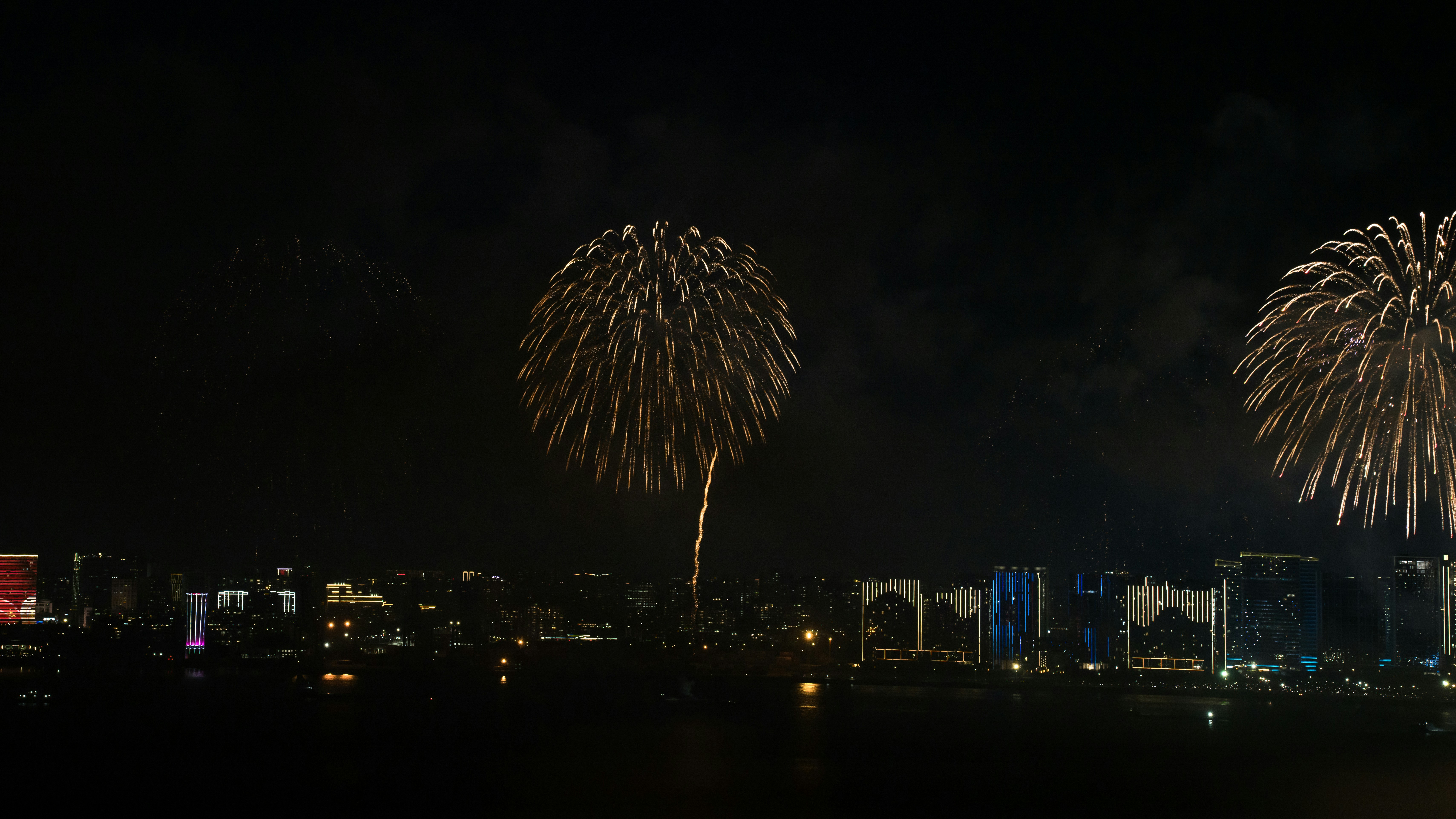 aerial night view of crowded city riverbank festival fireworks